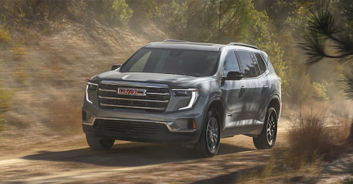 2025 GMC Acadia driving through a dirty road