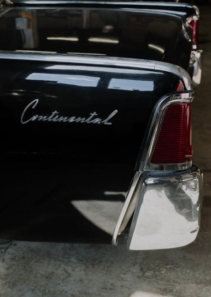 Vintage black, Lincoln Continental parked in a garage.
