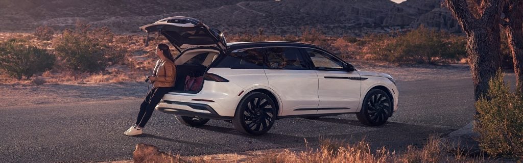 White SUV parked in a desert landscape with tailgate