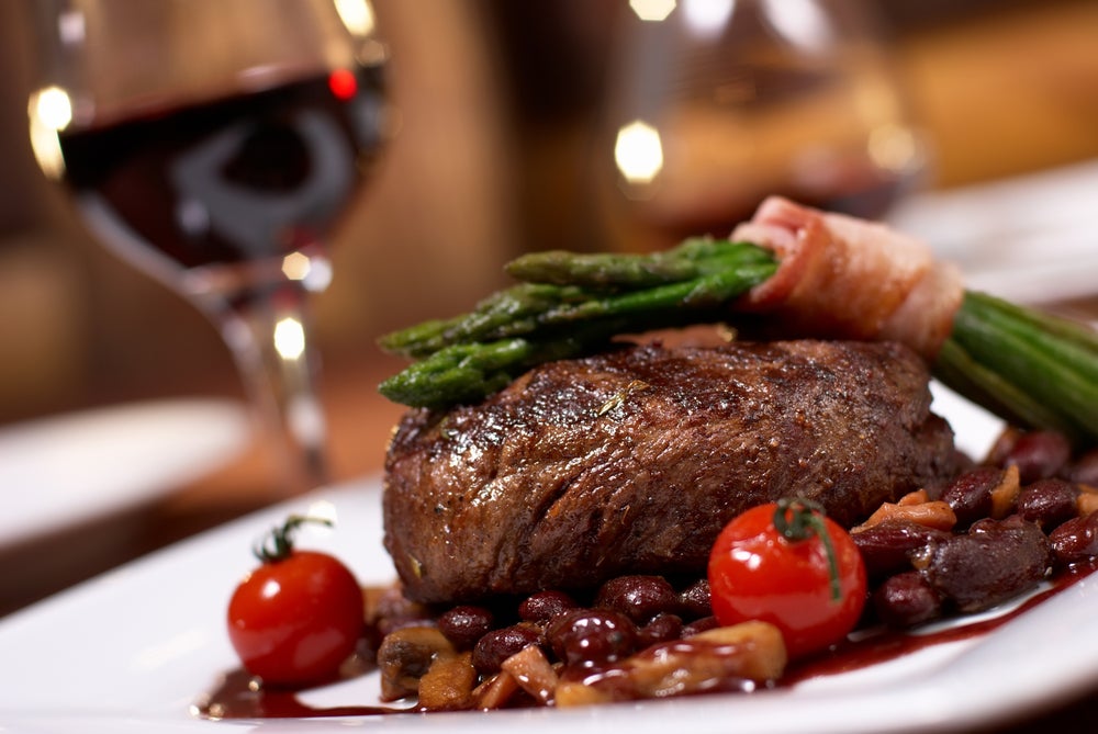A nice steak topped with bacon-wrapped asparagus