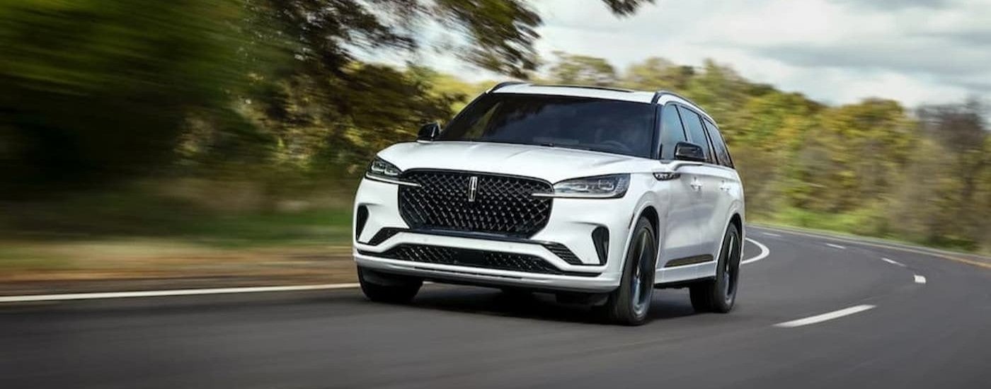 A white 2026 Lincoln Aviator driving on a highway.
