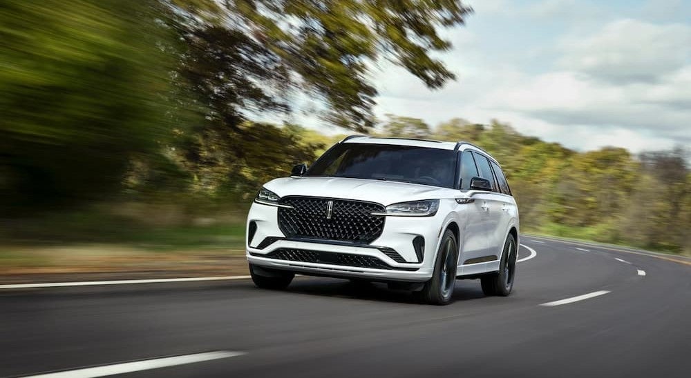 A white 2026 Lincoln Aviator driving on a highway.