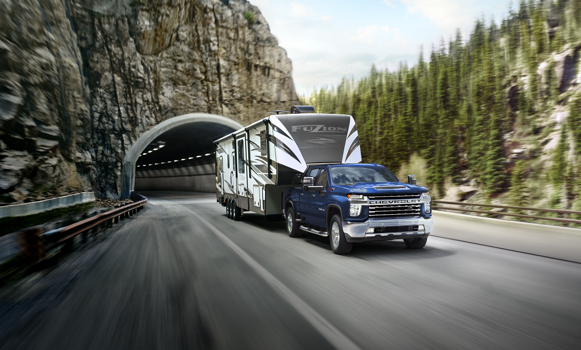 Blue Chevy Silverado towing large black and white trailer