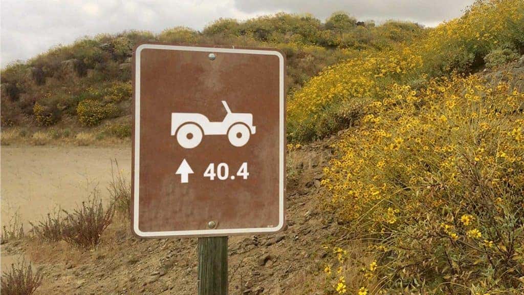 a Jeep teaser with a sign reading 40.4 with a dirt track behind it.