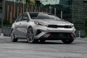 A gray 2022 Kia Forte GT parked outside a building.
