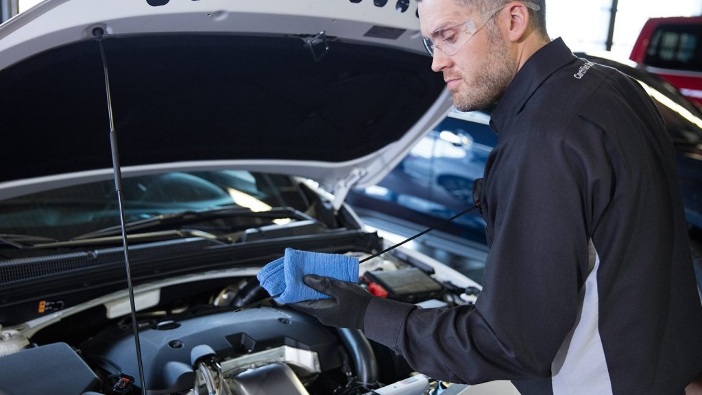 A service tech performing routine maintenance on a vehicle near Frederic, WI