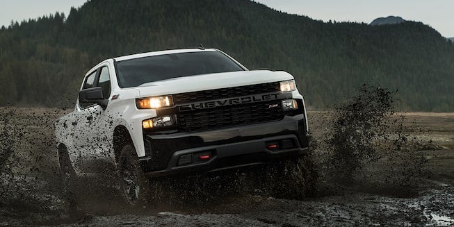 A Chevrolet Silverado powering through the mud