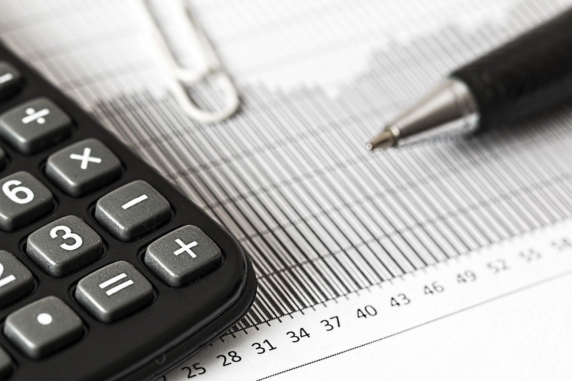 Close-up of a spreadsheet with a calculator and pen