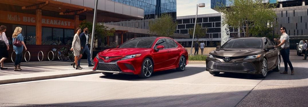 Red and Brown 2020 Toyota Camry Models in an Office Parking Lot