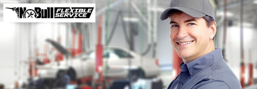 Smiling Mechanic in a Garage with Black No Bull Flexible Service Logo in Upper Left Corner