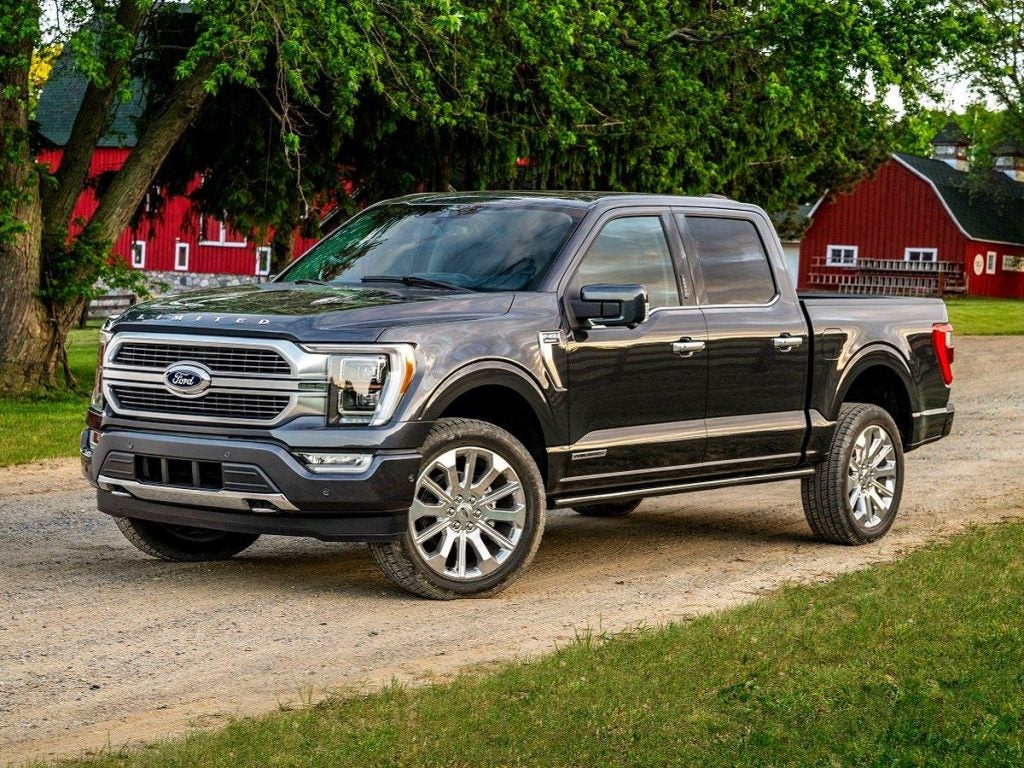 A black 2022 Ford F-150 parked in front of a farm house.