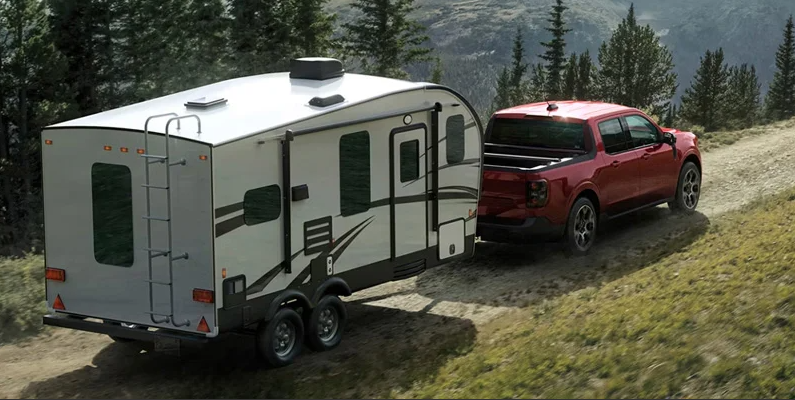 A photo of a red 2026 Ford Maverick towing a camper