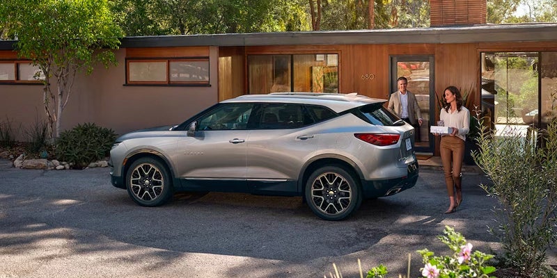 A photo of a gray 2024 Chevy Blazer parked outside of a home.