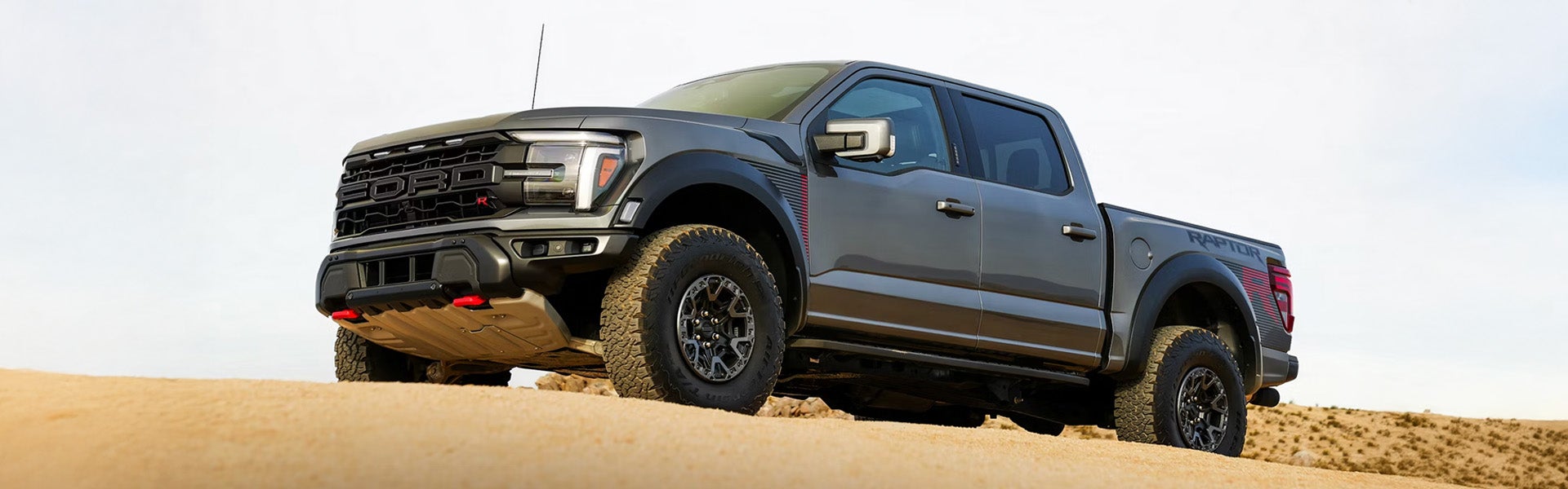Ford Raptor pickup on desert terrain.
