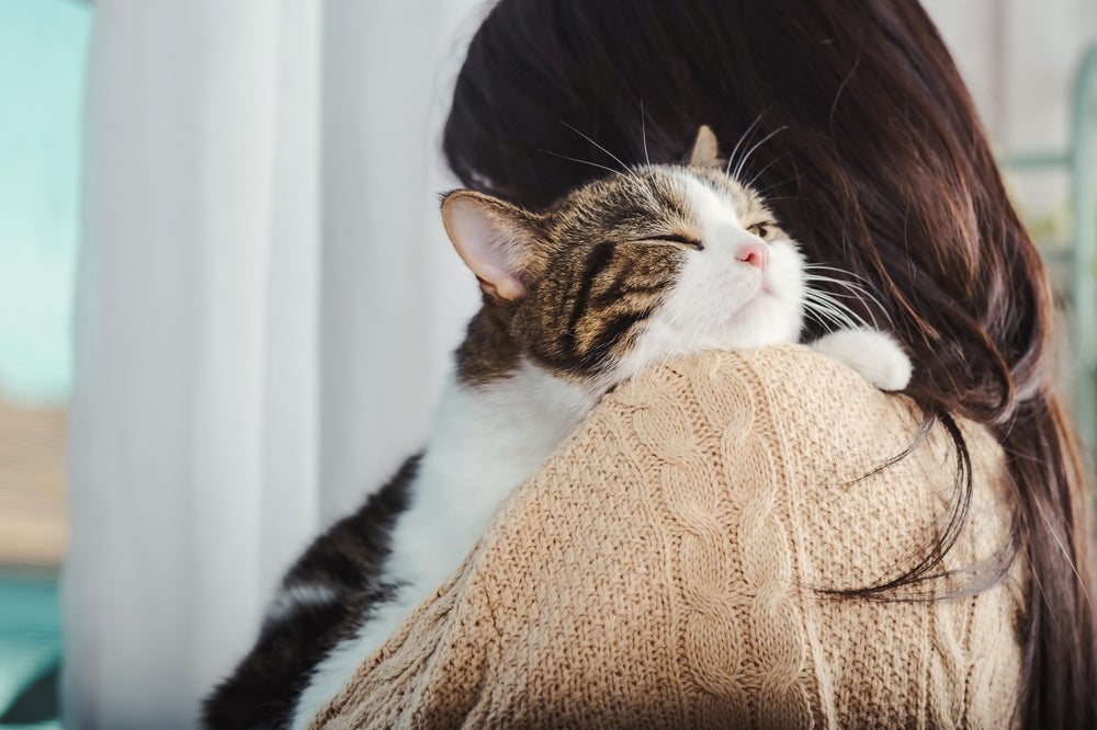 A photo of a woman hugging a cat