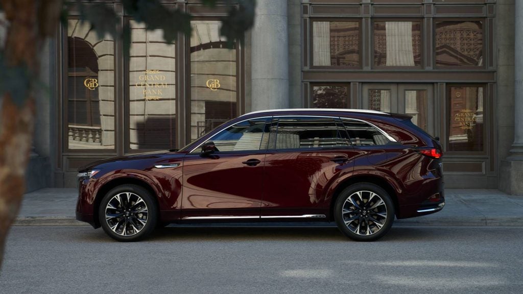 a burgundy mazda suv parked in front of a bank 