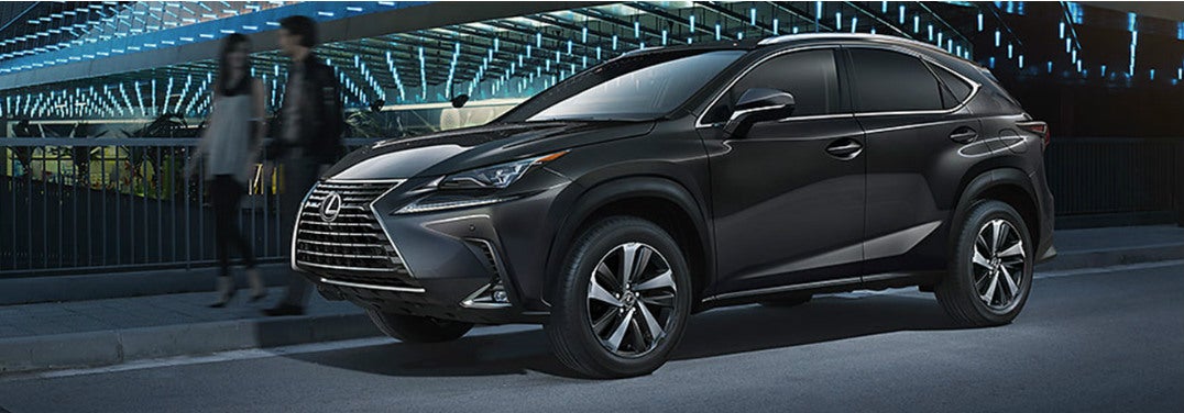 2019 Lexus NX parked outside a well-lit futuristic stadium.