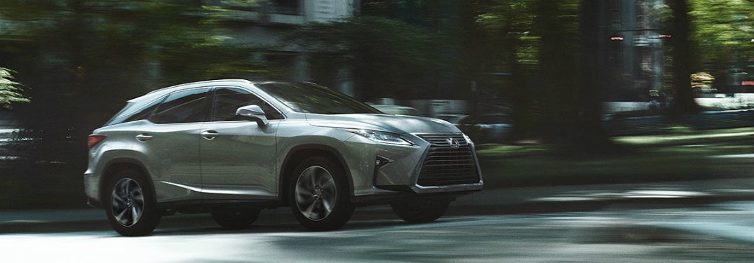 Metallic 2020 Lexus RX drives along a city street,