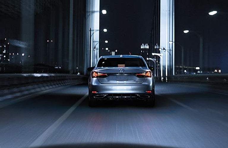 A view of a 2020 Lexus model keeping its distance on the road at night.