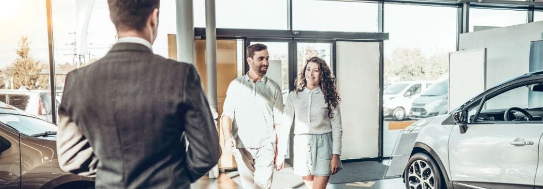 Young Couple Walking into a Car Dealership