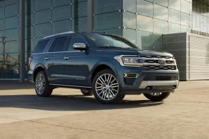 A 2022 Ford Expedition Platinum parked in front of a glass building.