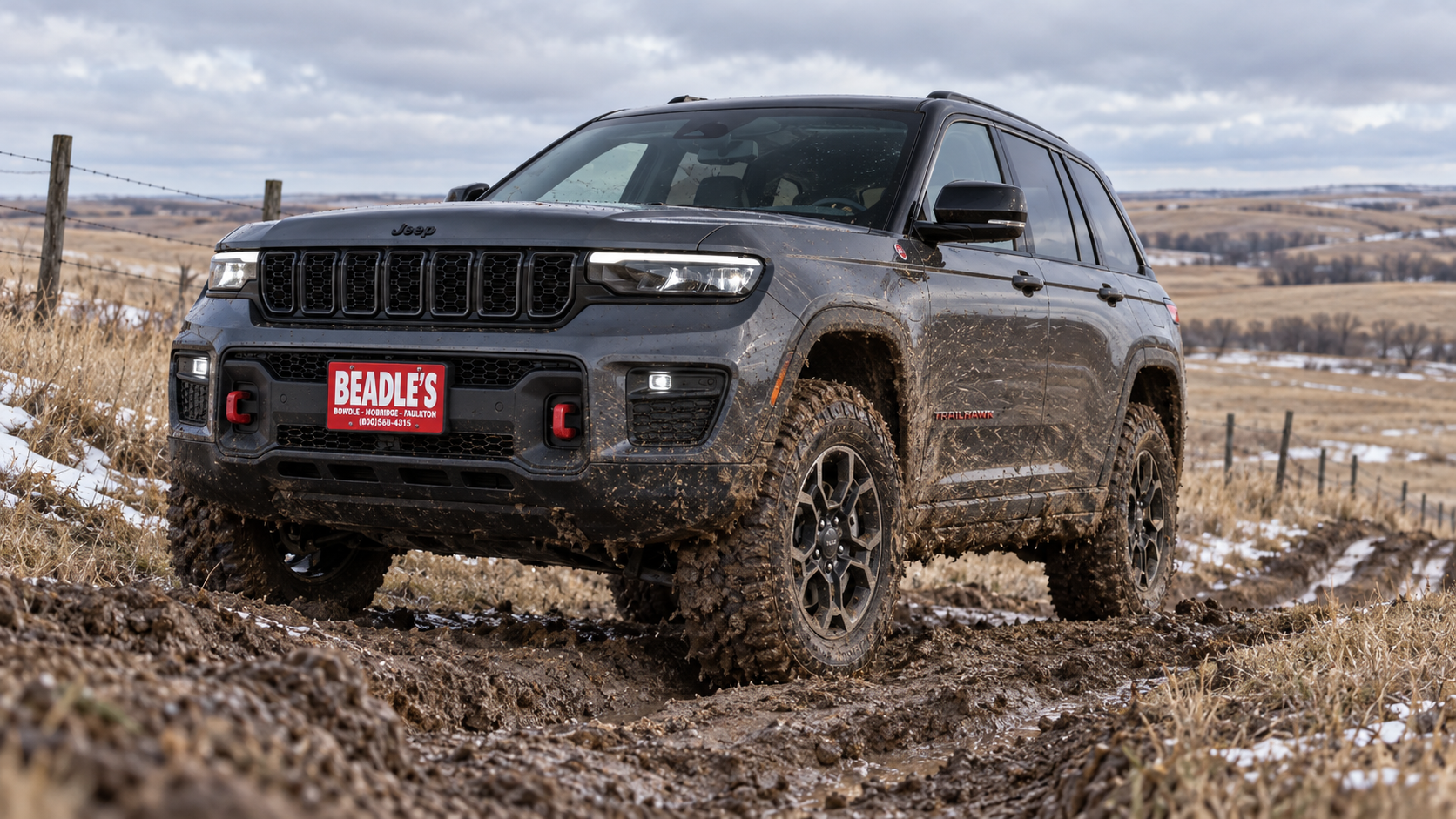 2027 Jeep Grand Cherokee Trailhawk climbing a muddy grade, at Beadle's Chrysler Center