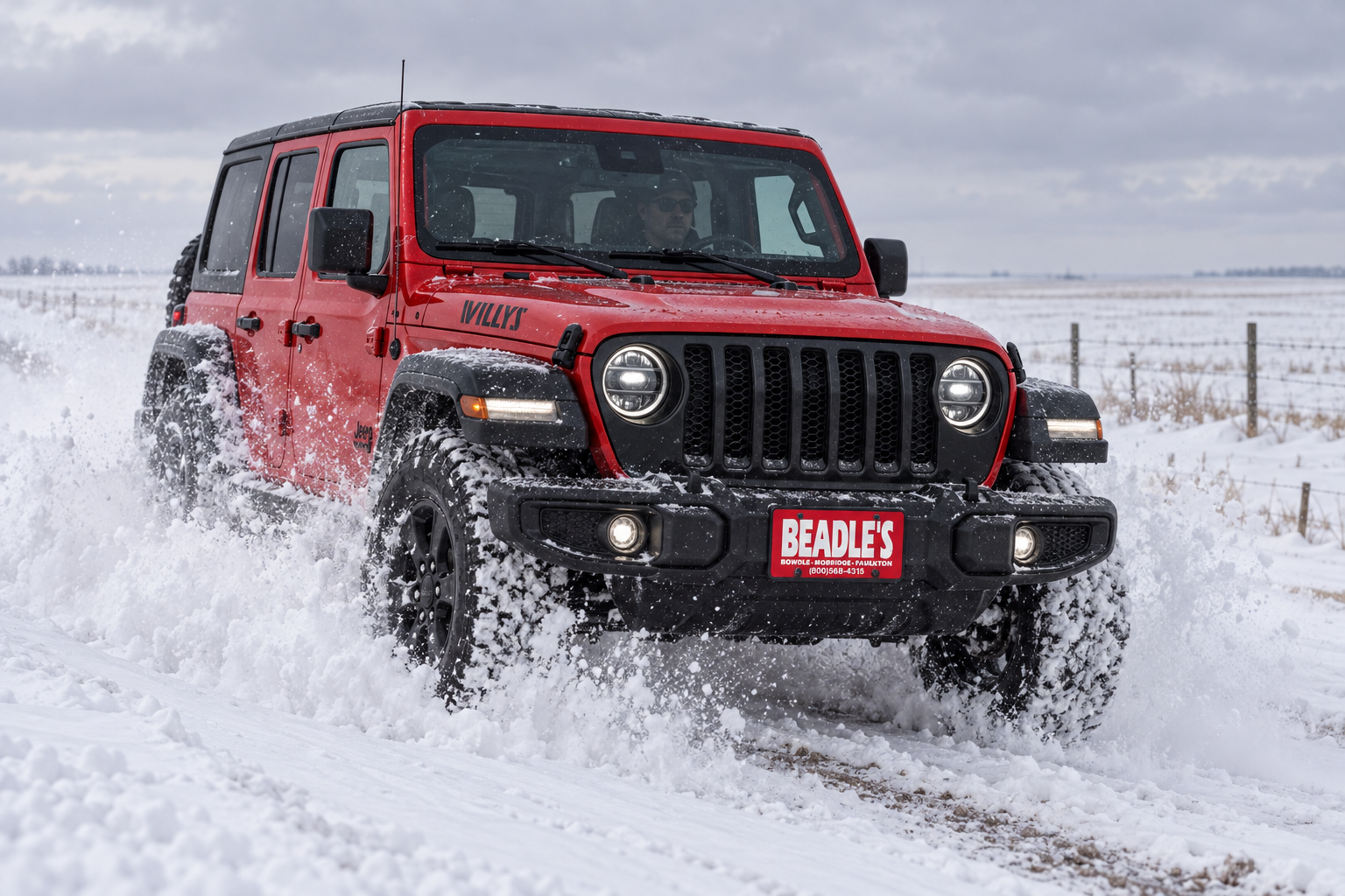 Jeep Wrangler Willys driving through a snow drift on an unplowed South Dakota road, 2027 winter guide, at Beadle's Chrysler Center