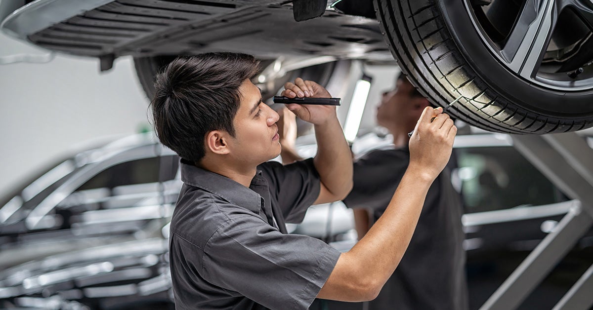 GMC service tech inspecting tires