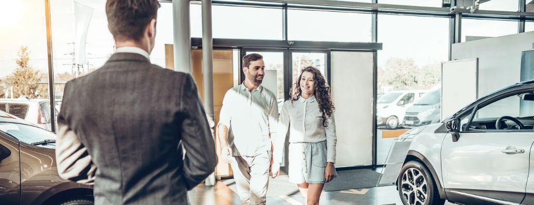 Young couple walking into dealership