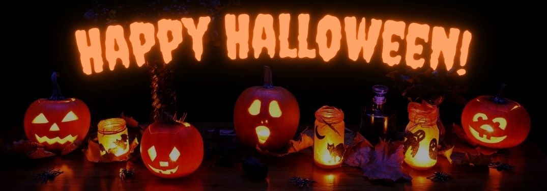 Lit Halloween Jack-o-Lanterns on a Table with Glowing Orange Happy Halloween Text