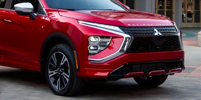 Front corner view of a shiny red Mitsubishi Eclipse Cross SUV.