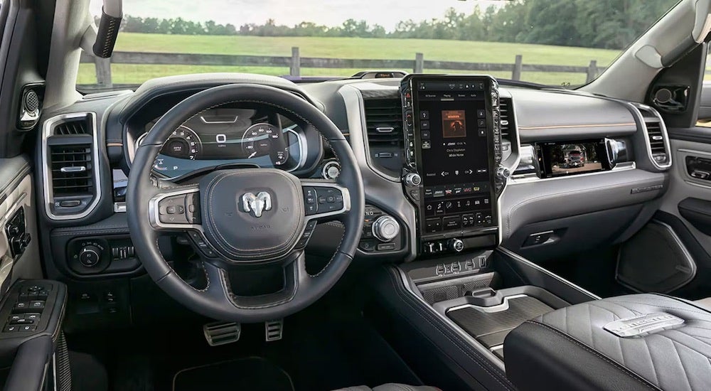 The black interior of a 2025 Ram 1500 is shown from the driver's seat.