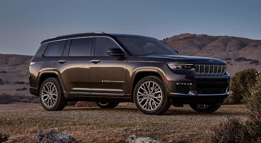 A black 2024 Jeep Grand Cherokee parked off-road and angled right.