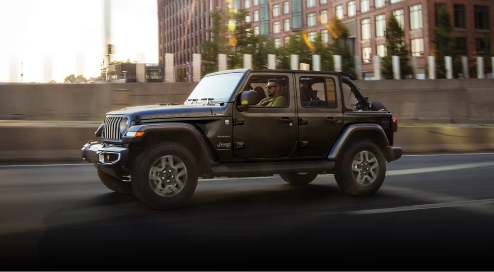 A grey 2025 Jeep Wrangler Unlimited Sahara driving to a Jeep dealer near Springfield.