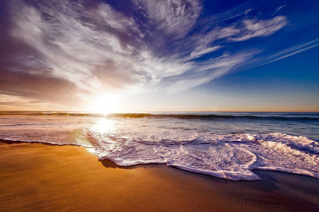 Ocean waves crashing on shore during Sunset