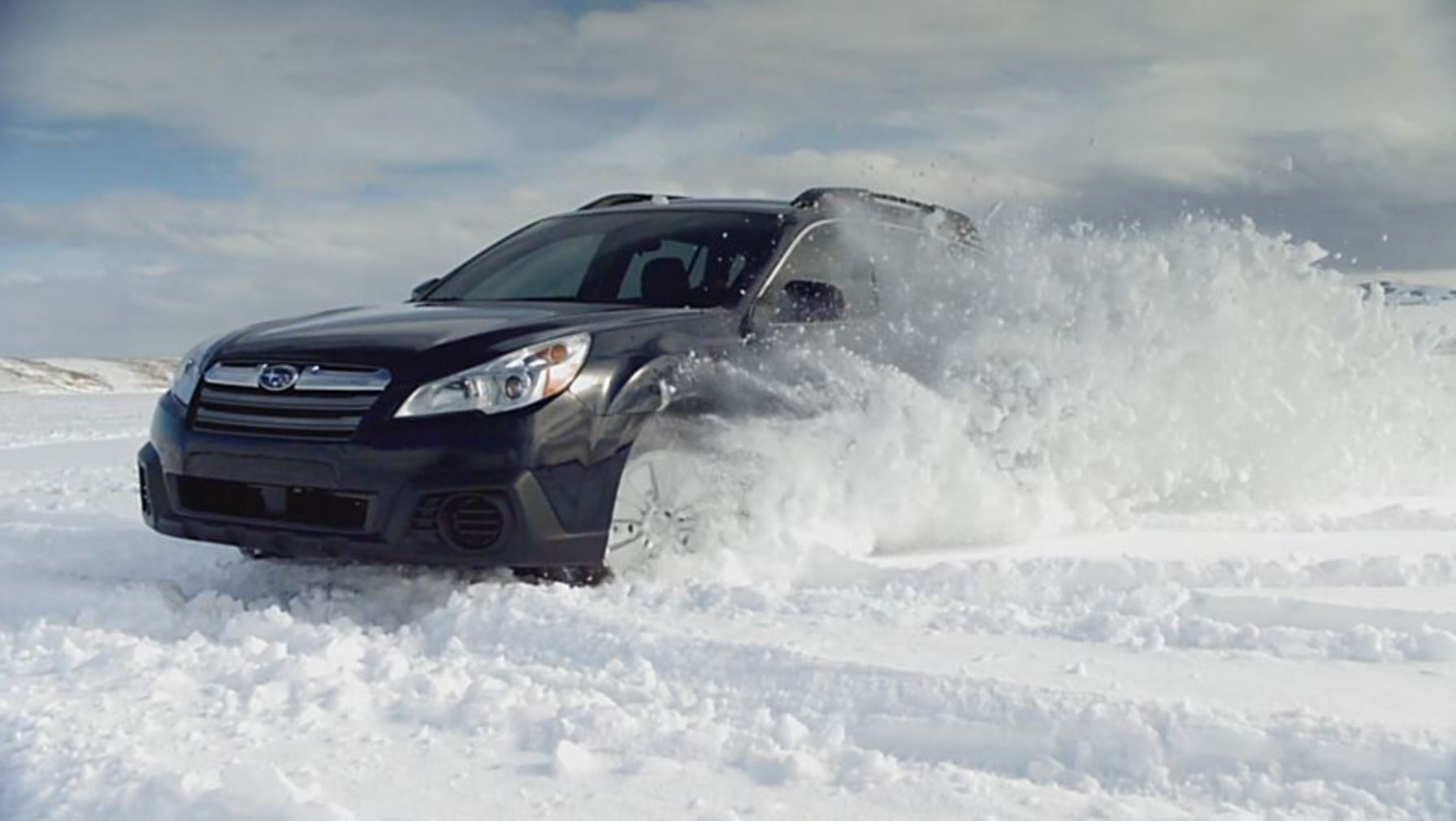 Subaru Driving Through Snow