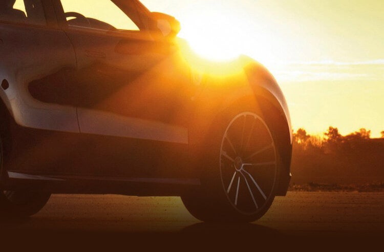 A car sits under the summer sun.