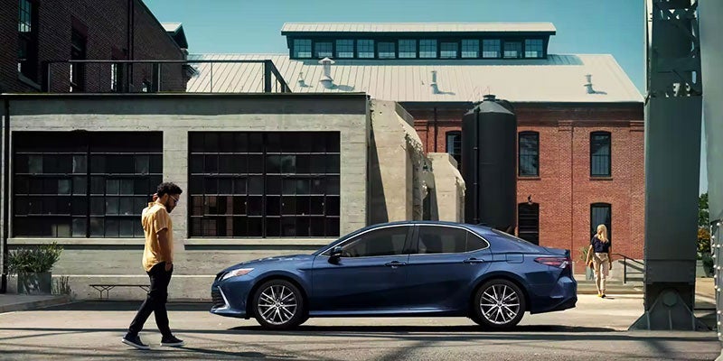 23 blue toyota camry with people in front of a house