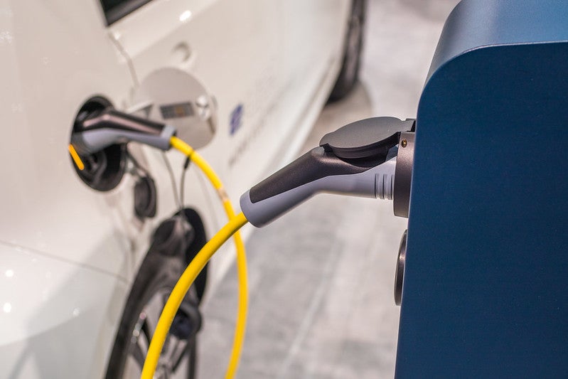 An electric car being charged zoomed on the charger