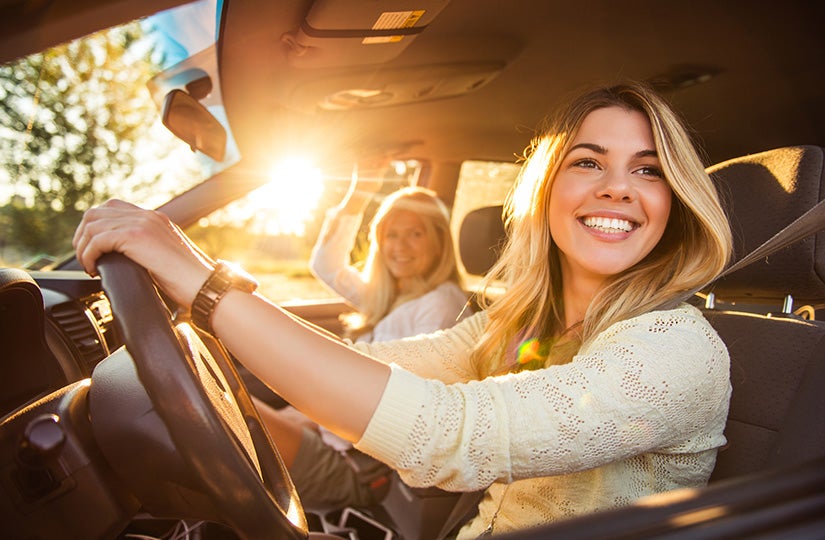 Women sitting in the front passenger and driver seat smiling from excitement after getting financing through North County Ford Financing department.