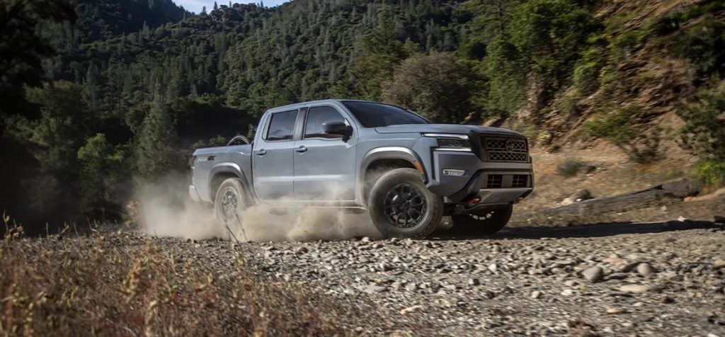  a grey truck driving through dust 