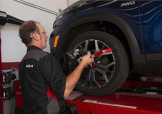 Service technician repairing the tire of a Kia