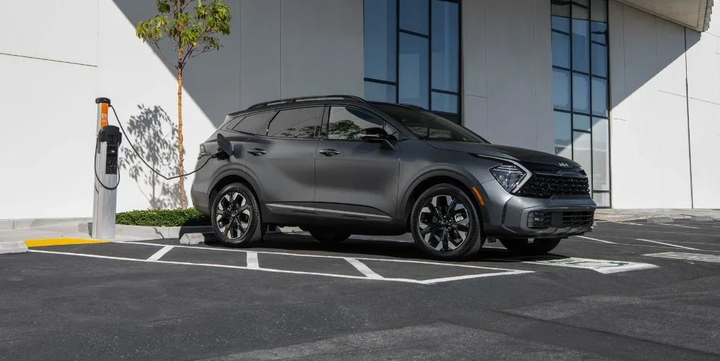 Black 2024 Kia Sportage Plug-In Hybrid charging at station