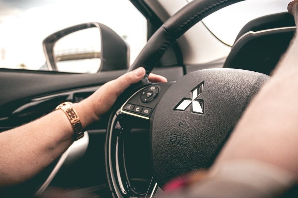 close up image of two hands on a steering wheel 