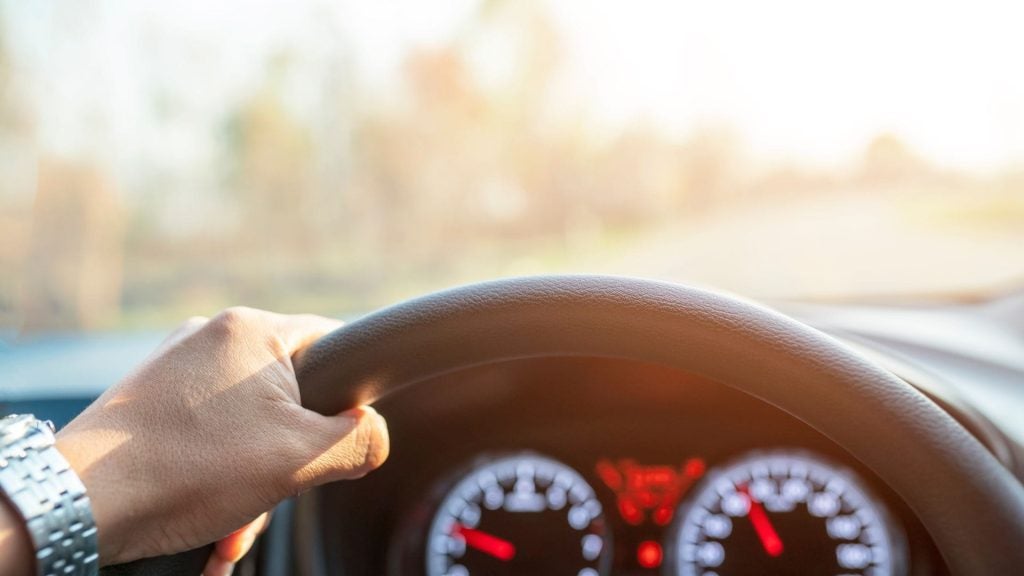 close up shot of a hand on a steering wheel 