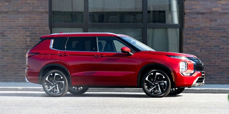 brand new red 2023 Mitsubishi Outlander parked on a city street