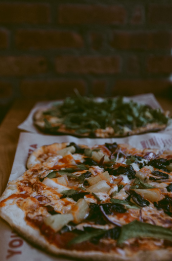 Two gourmet pizzas on a table of a Dublin, CA pizza shop.