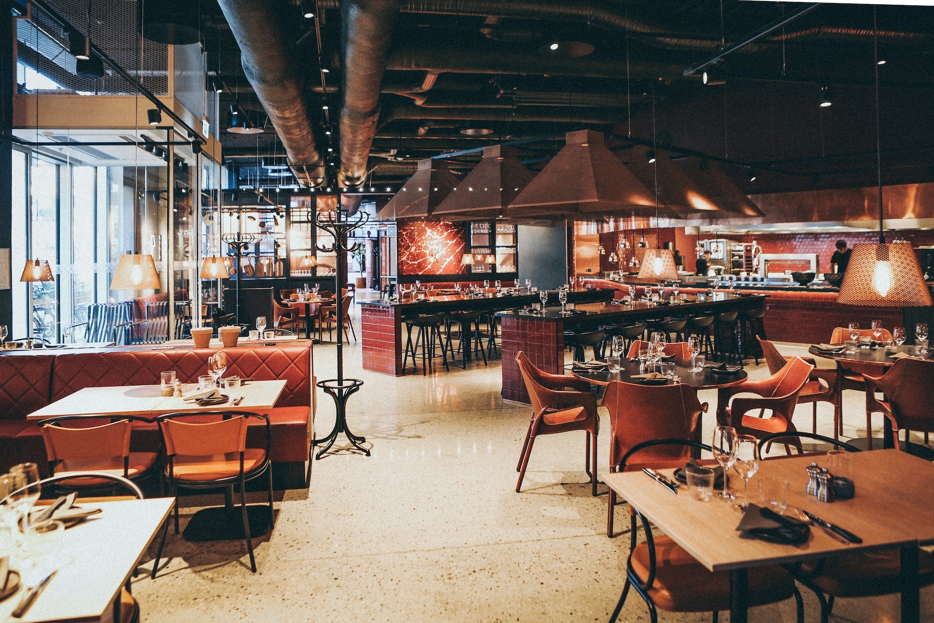 The inside of a restaurant with tables set up and ready for guests