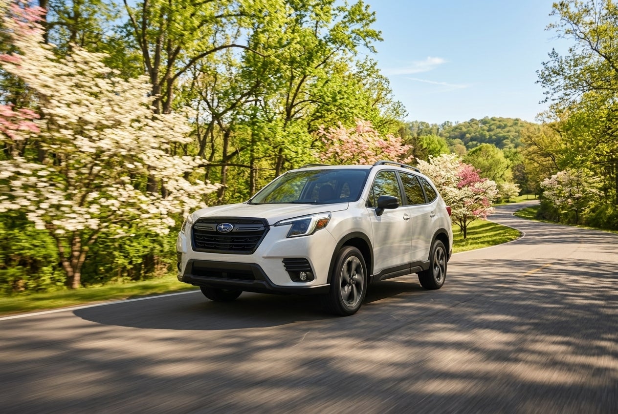 A new Subaru Forester driving through a scenic Missouri landscape during spring.