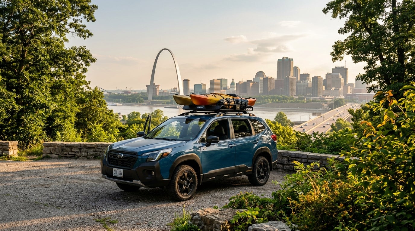 A cinematic, wide-angle shot of a 2026 Subaru Forester in a sleek metallic harbor blue parked on a scenic overlook in St. Louis, the iconic stainless steel Gateway Arch and the city skyline shimmering in the hazy distance under a clear summer sky, lush midwestern greenery and dense oak trees of a Missouri park framing the composition, the vehicle equipped with a rugged roof rack carrying outdoor gear, warm late-afternoon golden hour sunlight casting a soft glow across the car’s modern body lines, vibrant saturated color palette of deep forest greens and bright azure blues, ultra-realistic automotive photography style, low-angle three-quarter view emphasizing the SUV's ground clearance, atmospheric summer humidity adding a soft depth to the horizon, sense of adventure and regional pride.